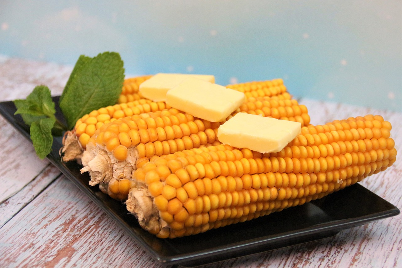 Corn on the cob, plated with garnish.