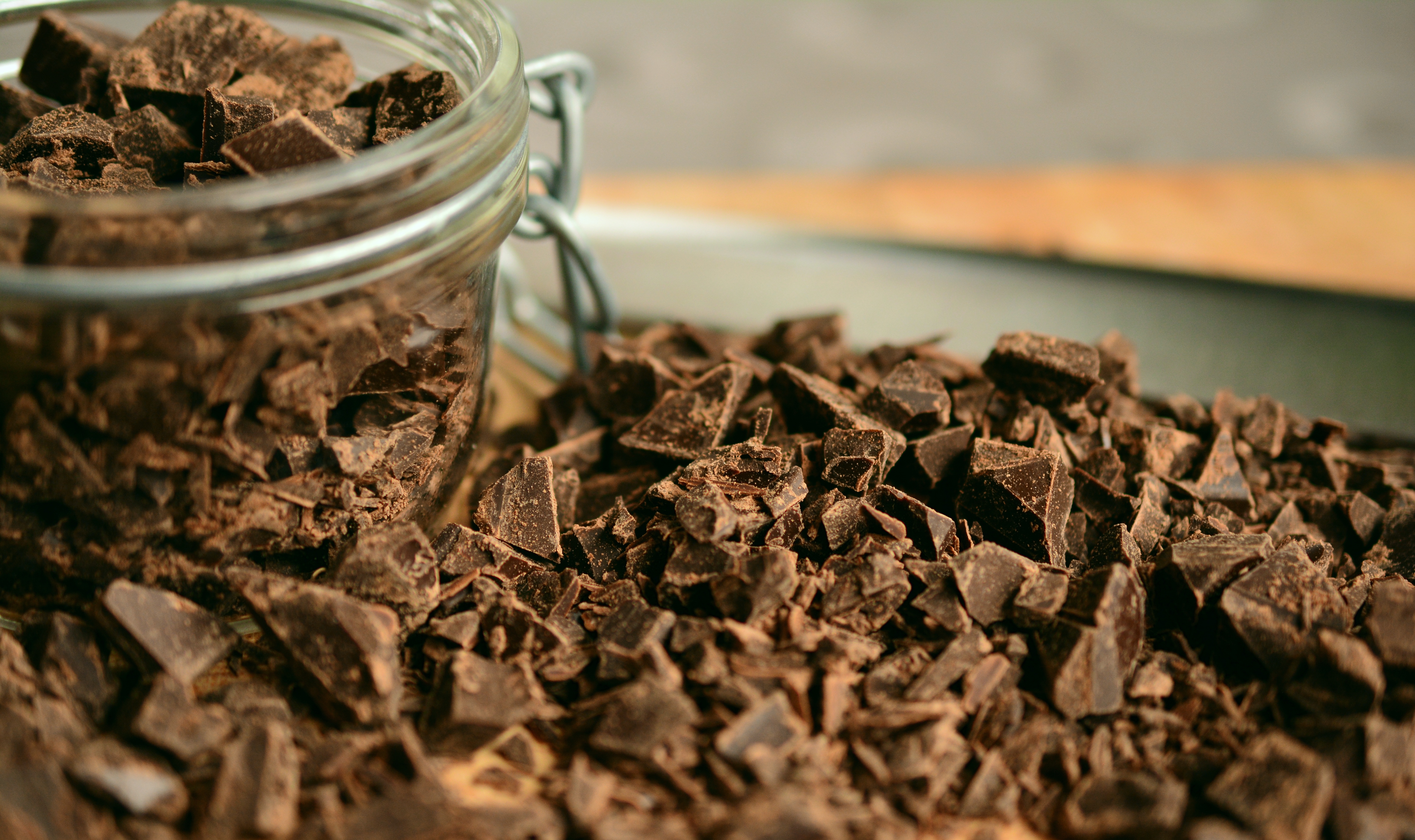 A mason jar filled, and surrounded, with chopped chocolate.