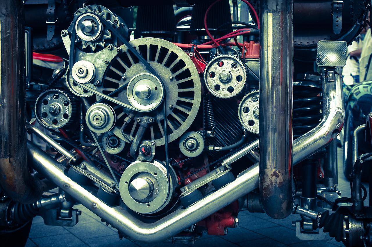 A motor with a lot of cogs, wheels and bands.