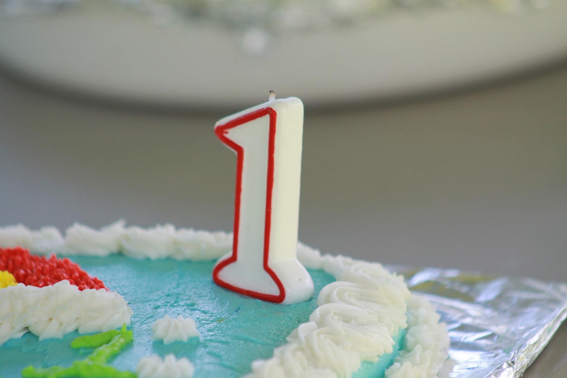 A birthday cake with a candle in the shape of the figure one.