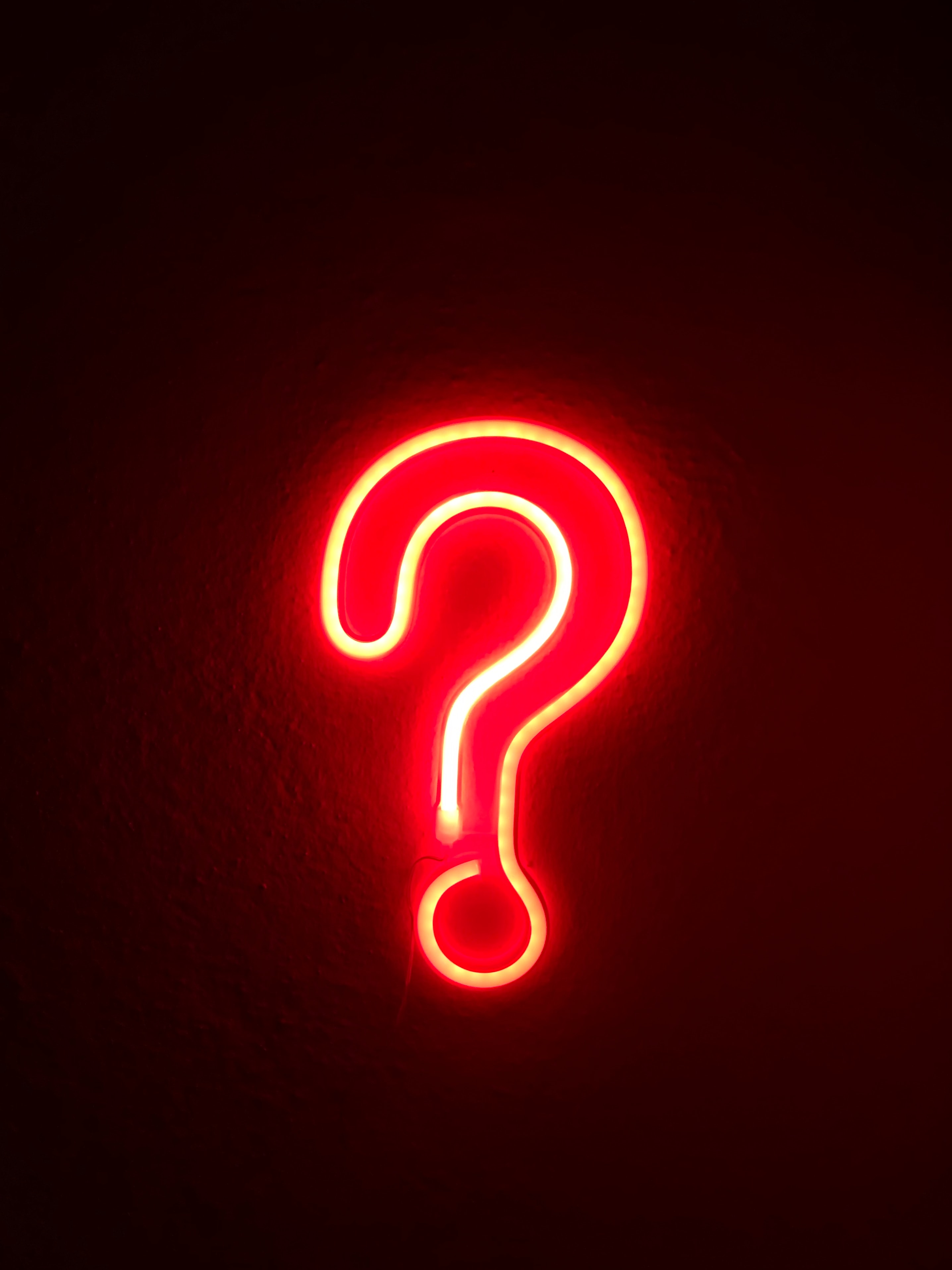 A red neonsign of a questionmark